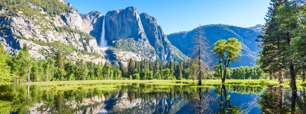 Yosemite National Park - Reflection in Merced River of Yosemite waterfalls and beautiful mountain landscape, hiking in the beautiful nature of California, USA