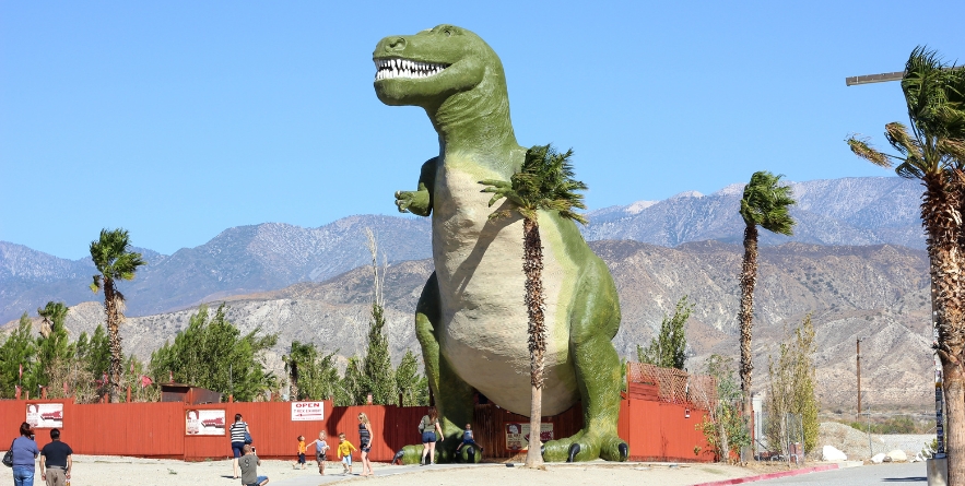 Cabazon Dinosaurs T-rex looming over the palm trees in the California desert