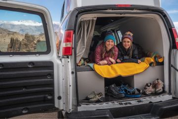 People sitting in back of camper